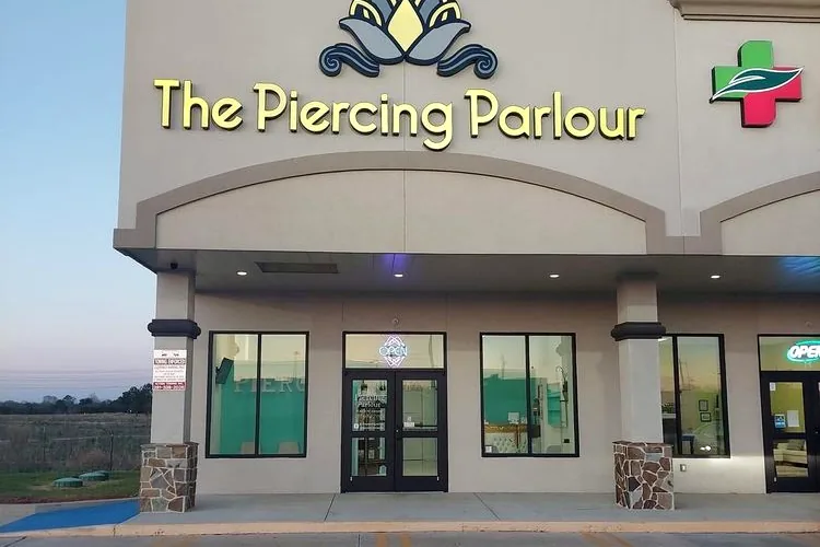 The Piercing Parlour storefront on the Gulf Freeway in Webster, Texas at dusk